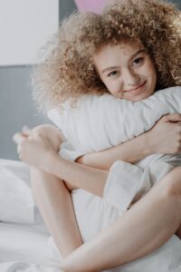 woman in white long sleeve shirt lying on bed